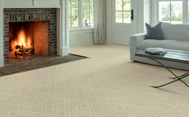 cream patterned carpet in living room transitioning to tile fireplace