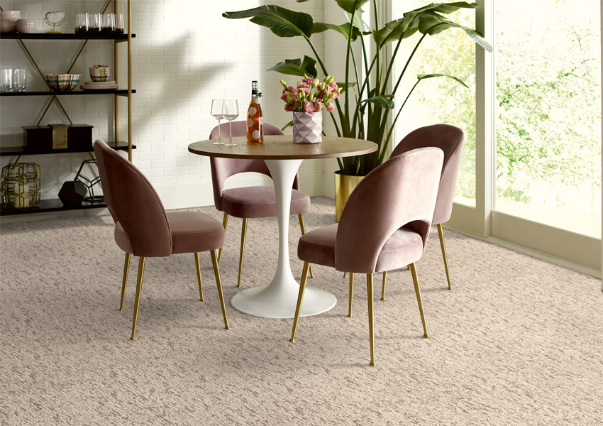 beige patterned carpet flooring in dining room with dining table and velvet chairs